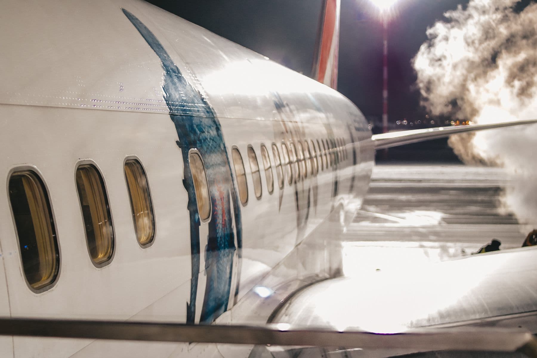 An airliner under floodlights on a night stand
